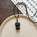Vue détaillée du pendentif chat en bois noir sculpté main avec des yeux en cristal - Style Chat Noir / Noir