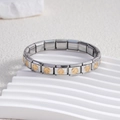 Dettaglio delle maglie del bracciale italiano in acciaio inossidabile con segni di pace dorati - Centro Oro