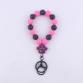 Detail of pink and black silicone bead bracelet with a paw print charm and metal keyring - Rose Red