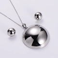 Set collana con pendente a semisfera argento e orecchini a lobo su sfondo grigio - Set di Gioielli Color Acciaio