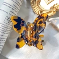 Elegant tortoiseshell butterfly hair claw clip with amber brown pattern on white silk fabric - Butterfly Shape / Amber