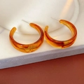 Macro detail of retro C-shaped resin amber earrings on a white velvet jewelry stand - Amber (Coffee)
