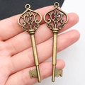 Vintage bronze alloy heart key pendants shown in hand for scale and texture - Antique Bronze Hollow Key (8752)