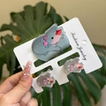 Detailed view of three gray acrylic mouse hair clips with pink bows on a display card - Polka Dot Pink Bow Hippo Clip 3PCS Set