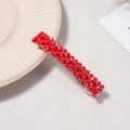 Détail d'une barrette à perles de cristal rouge sur une assiette en céramique - Rouge Uni