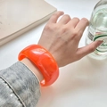 Minimalistischer breiter Armreif aus orangefarbenem Harz mit polierter Oberfläche - Innendurchmesser 67.2mm / Gewicht 67g / Helles Orange