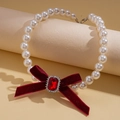 Macro shot of red velvet bow with square gem and pearls on a vintage necklace - Necklace-Red
