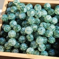 Detailed macro view of green marbled glass beads with gold accents in a wooden box - 10mm / Green Demon