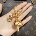 Close-up of golden mushroom keychain with red rhinestones on a designer handbag - Gold with Red Rhinestone Mushroom