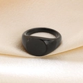 Minimalist black matte 18K gold-plated titanium signet ring on champagne silk fabric - US 7 / Black