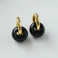 Detailed view of gold hoop earrings featuring polished black agate bead pendants - Black Agate