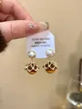 Makro-Detail von 18K vergoldeten Tropfenohrringen mit Perlen und Bernsteinsteinen - Silberner Ohrstecker-Gold-Kaffee