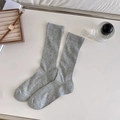 Grey ribbed mid-calf ballet style socks laid flat with lifestyle accessories - Light Gray