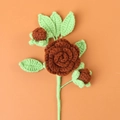 Handmade crochet brown rose flower with green leaves on an orange background - Finished Camellia Bouquet (brown)