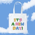 White canvas tote bag featuring colorful IT'S A NEW DAY! printed text and dual handles - It's A New Day! / Fun Graffiti