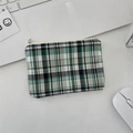 Flat lay of a green plaid coin purse with zipper on a white desk with office tech - Diagonal Green-Black Grid
