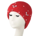 Winter red knitted hat with faux pearls and sparkling crystal bow accents on a mannequin - Red