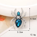Silver alloy spider brooch featuring blue drop gems and white crystal pavé legs - Antique Silver Blue Gem Spider