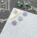 Detail of 3D iridescent camellia nail art charms with crystal roses on light blue background - 8mm / Purple