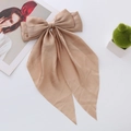Detail of elegant champagne satin bow hair clip with long ribbons and silky texture - Champagne