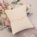 Detail eines rosa gewebten Boho-Armbands mit Muschel und bunten Perlen auf einem Kissen - Muschel Dekoriert Rosa Gewebter Stil (5#)