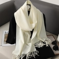 Close-up of soft cream white cashmere-like scarf featuring elegant tassel fringe details - Off White
