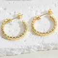Detailansicht der vergoldeten Gliederketten-Ohrringe auf einem weißen Steinsockel - 14K Goldener Ohrring (ES2256)