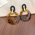 Detail view of retro leopard print resin hoop earrings on a textured fabric and wood surface - 44# Silver Earring Post-Coffee (Leopard Round Buckle)