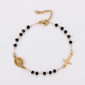 Detalle de pulsera religiosa con cuentas negras y medalla de la Virgen María dorada - Dorado
