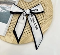 Classic black and white silk scarf with Blind For Love slogan tied in a bow - White Blind for Love