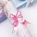 Close-up of a pink plastic pull bow with gold edges for festive gift packaging - Pink Gold Edge