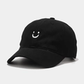 Close-up of premium black cotton baseball cap featuring white smile embroidery - Adjustable / Black