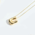 Minimalist gold necklace featuring a polished abstract organic U-shaped pendant - Letter U