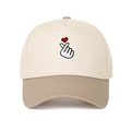 Dettaglio del ricamo cuore con le dita su un cappello da baseball beige e kaki - Beige/Cachi