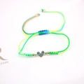 Detail of adjustable woven lucky bracelet featuring a heart pendant with blue zircon stones - Green