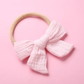 Detail of baby pink muslin cotton bow headband with soft khaki elastic nylon strap - Light Pink