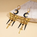 Creolen mit Mond Stern und Schwert Quasten auf dekorativem Stein Hintergrund - Schmetterling Mond Stern Schwert Anhänger Stil / Gold