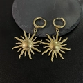 Dettaglio ravvicinato degli orecchini a cuore di sole placcati in oro 18K su fondo scuro - Sole Oro