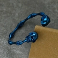 Macro shot of blue metallic skull open bracelet with intricate bone joint carvings - Blue