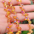 Macro detail of faceted orange gradient glass beads with sparkling light reflection - Golden Plum Red