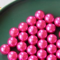 High-gloss bright pink ABS faux pearl round beads on a dark green decorative plate - Rose Red