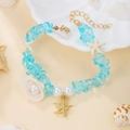 Detalle de la pulsera oceánica boho con piedras azules, estrella de mar blanca y cadena oro - Azul cielo