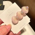 Close-up of three pink iridescent shell hair clips with pearls on a display card - 5* Large Shell - Pink