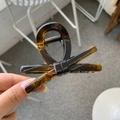 Detail of tortoiseshell bow hair claw clip with amber texture and strong metal spring - Glossy Light Tortoise
