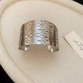 Detailed close-up of textured irregular silver bangle with unique wavy line patterns - Silver Wave Texture