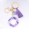 Detail of resin alphabet keychain with purple tassel and colorful crushed stone filling - Letter O