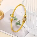 Golden open bangle with twisted texture and micro-pave zircon cylinder focal point - Size 5.6cm-Style 3