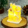 Close-up of glowing white Christmas resin house with red bow and artificial snow details - Style G