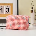 Quilted red and white checkered toiletry bag with blue bow prints and secure zipper closure - Plaid Red Bow