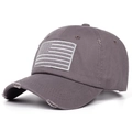 Close-up of a distressed grey baseball cap with a monochromatic American flag embroidery - Gray
